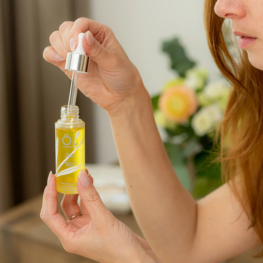 Femme qui utilise le sérum absolu ÖL cosmétiques sur son visage