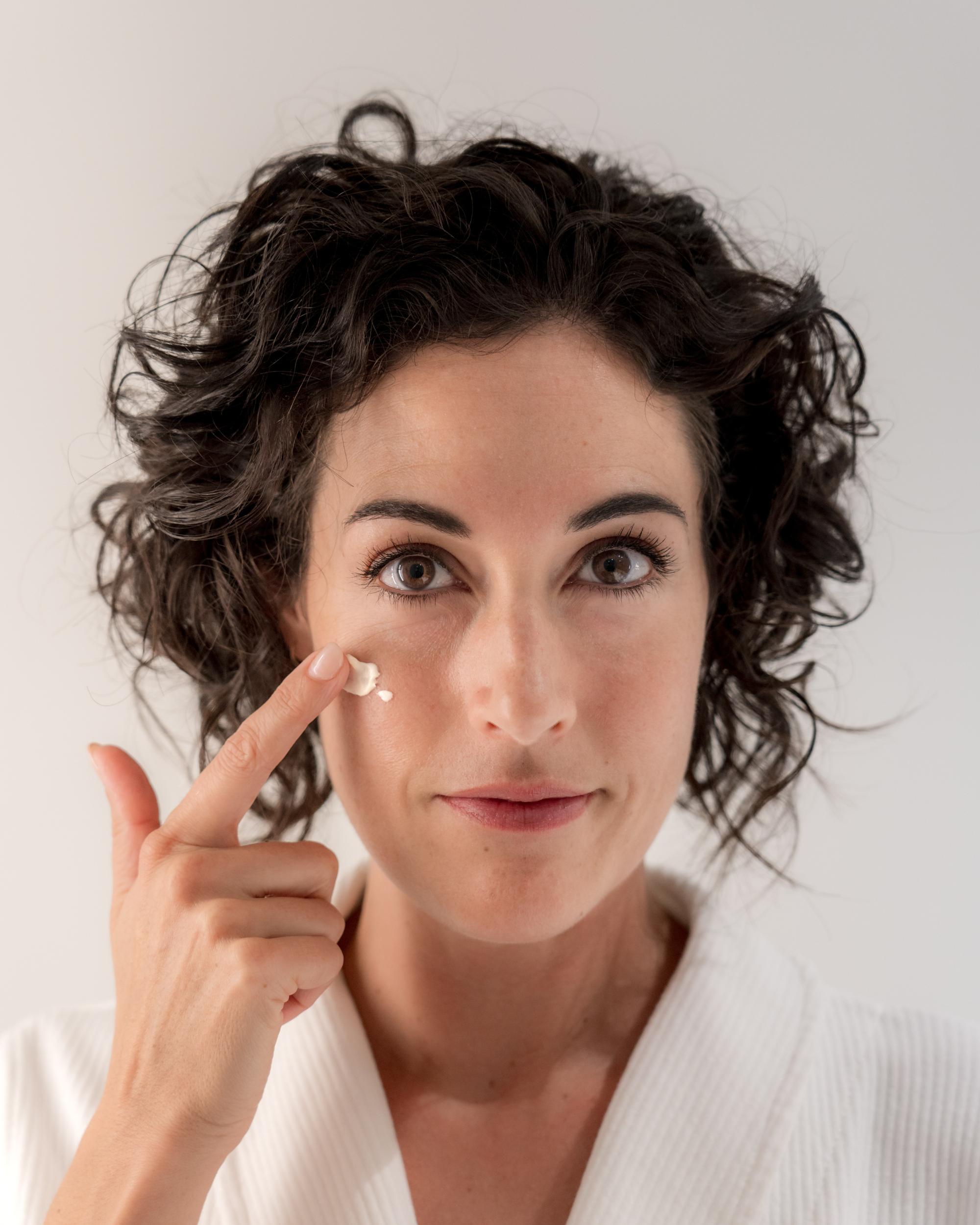 Femme qui applique de la crème hydratante sur son visage