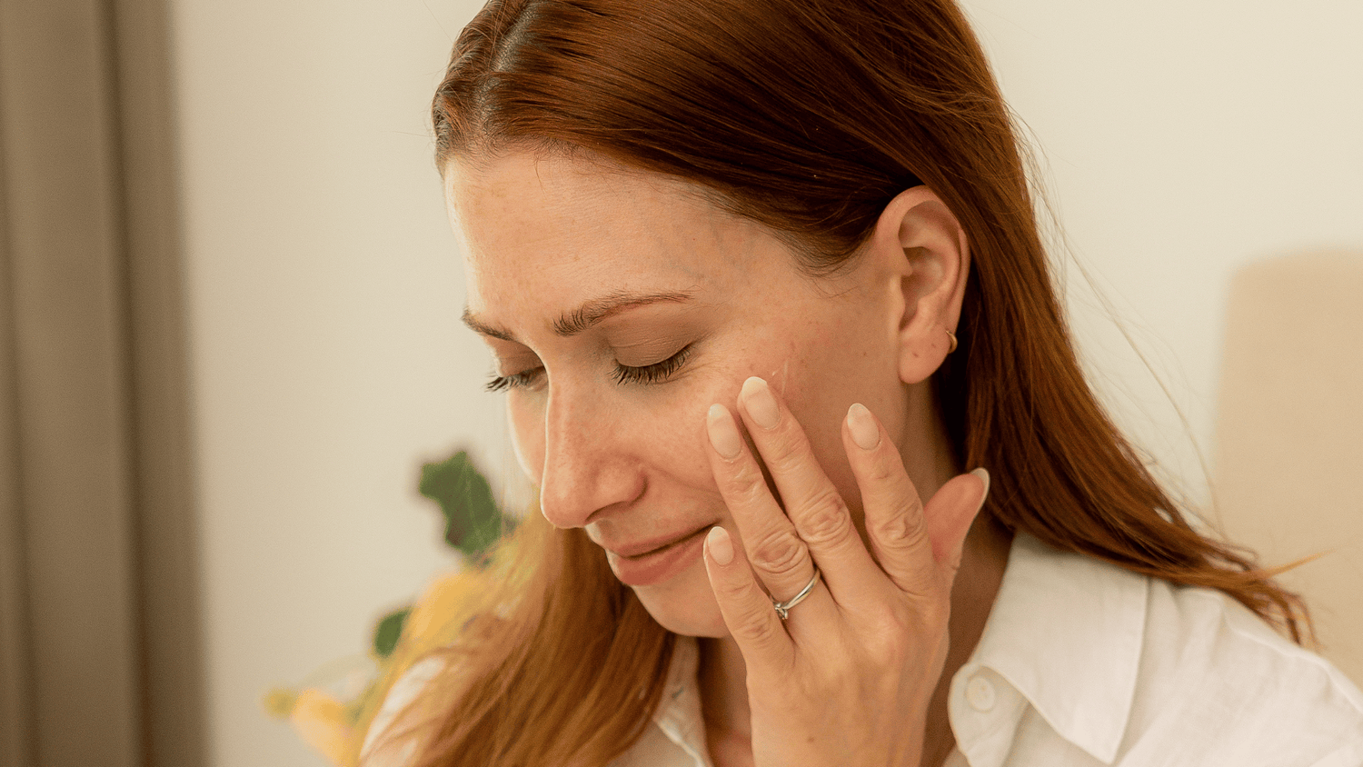 Femme qui applique de la crème sur sa joue