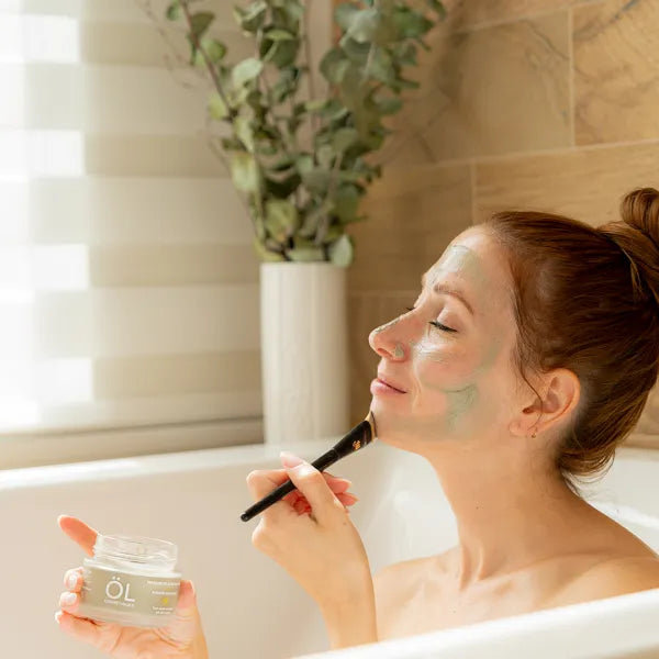 Femme qui applique sur son visage le masque de boue marine ÖL cosmétiques